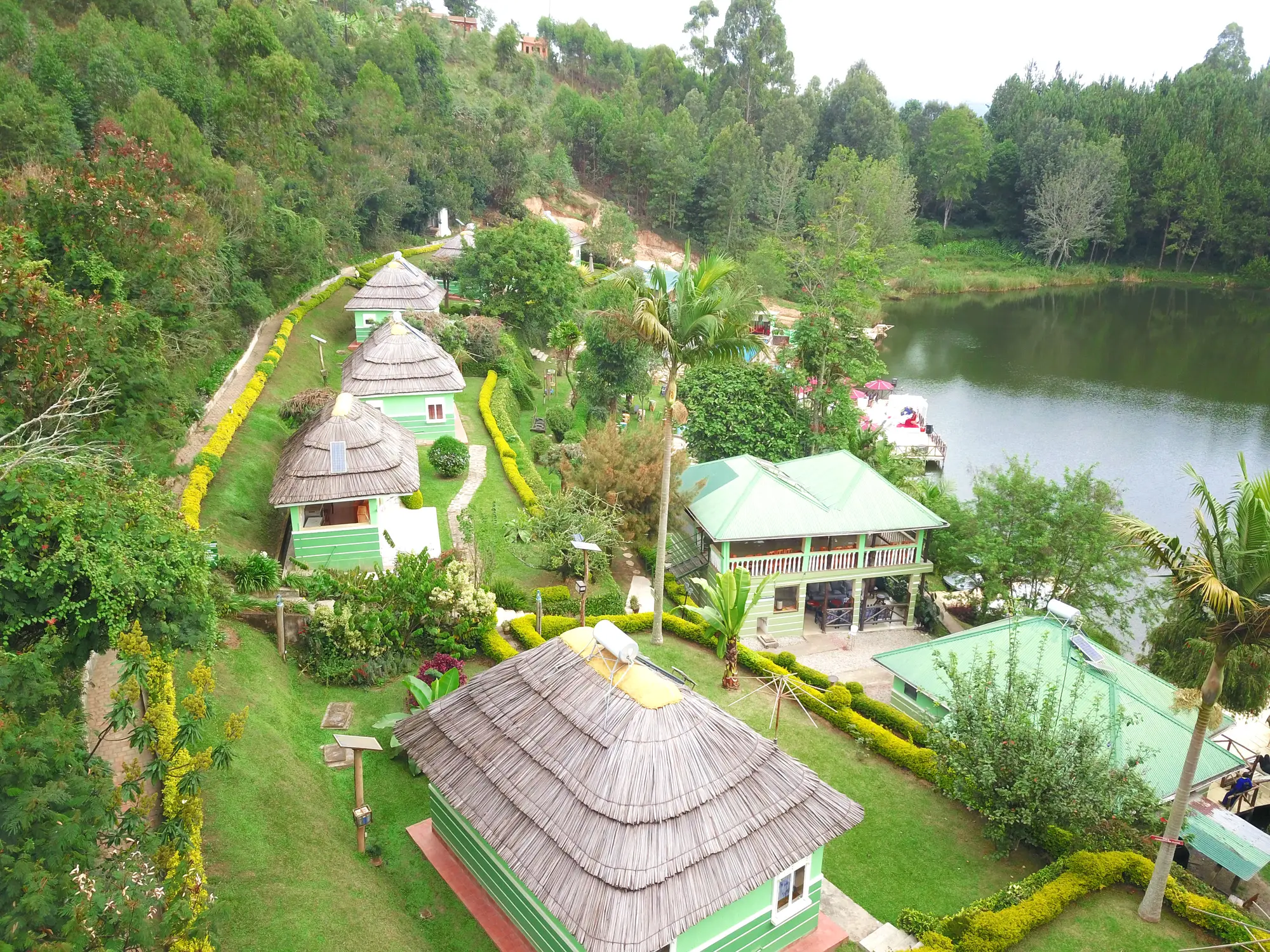 Aerial view of the thatched cottage roofs and lawns running down to the lake